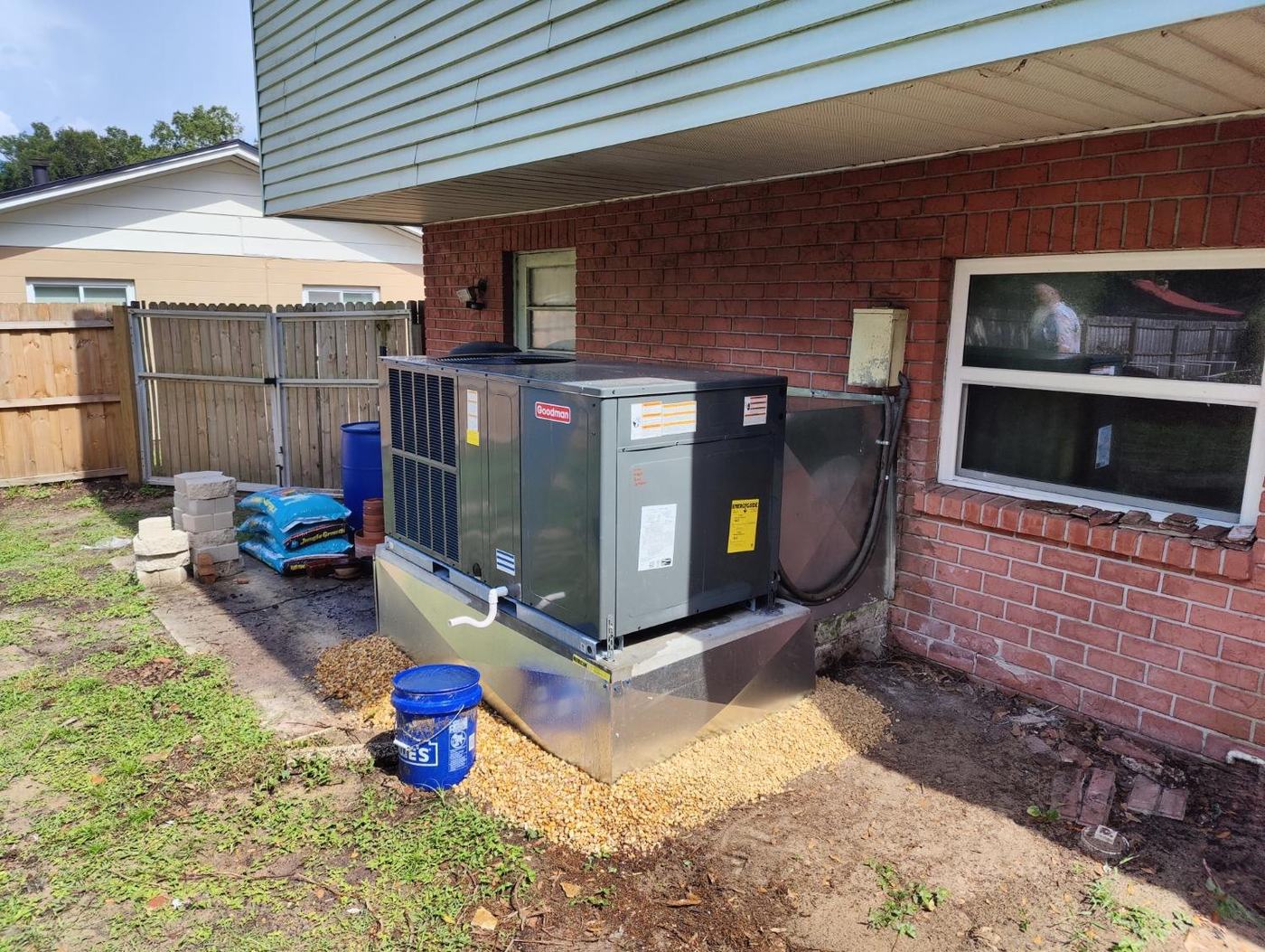 AC installation in Spring Hill TN — Goodman package unit on a raised metal curb